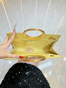 Sparkling evening clutch with gold metal handles and a detachable chain strap