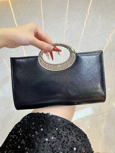Detail of black cross-grain leather evening bag with silver rhinestone metal ring handle