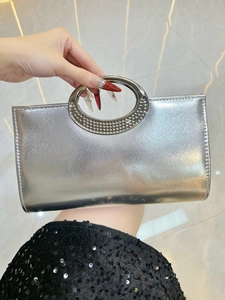 Silver glitter evening clutch bag featuring a round handle with shimmering rhinestone detail