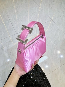 Detail of elegant pink satin hobo bag featuring luxury rhinestone buckles on handle