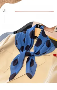 Dettaglio di un foulard in seta a pois blu su un blazer beige per un look da ufficio
