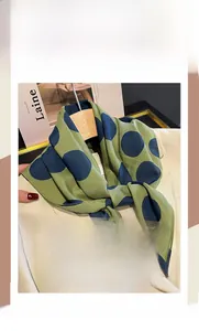 Foulard quadrato in seta e cotone a pois su un gancio di legno con blazer beige