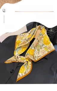 Detail of printed thin square scarf styled with a business suit for elegant neck styling