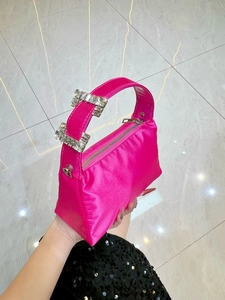 Detail of rose pink satin handbag with sparkling rhinestone buckles and silver zipper