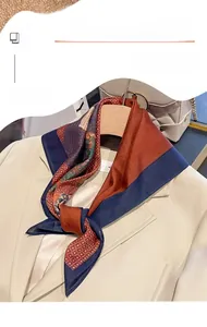 Detail of floral geometric printed silk scarf tied on a beige blazer for office wear