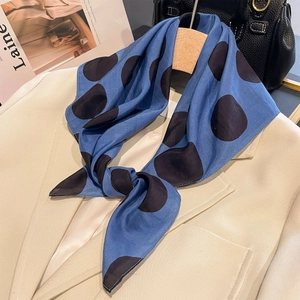 Foulard di seta blu a pois abbinato con un elegante blazer crema per un look da ufficio