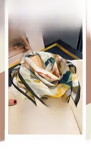 Detail of floral silk cotton square scarf with hand-rolled edges on beige blazer