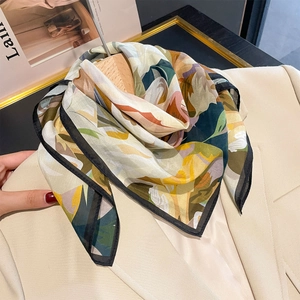 Elegant floral silk square scarf with colorful abstract botanical prints on a beige blazer