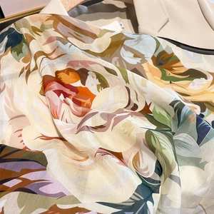 Satin floral silk scarf with vintage botanical print draped over beige outerwear
