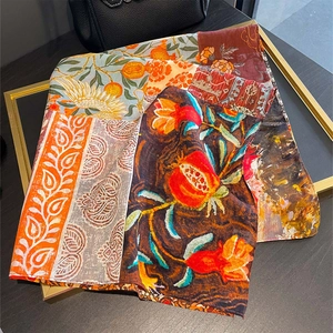 Vintage-Seidenschal mit Paisley-Blumenmuster auf einem goldenen Tisch präsentiert