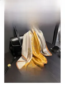 Detail of silk scarf with floral patterns, mustard yellow and grey contrast stitching