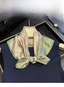 Close-up of 100% mulberry silk scarf with floral patterns on a dark navy vest