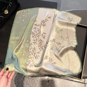 Detail of silk square scarf featuring bird and floral patterns with hand-rolled edges