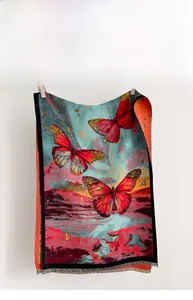 Detail of artistic butterfly print scarf with elegant fringe trim and vibrant sunset colors