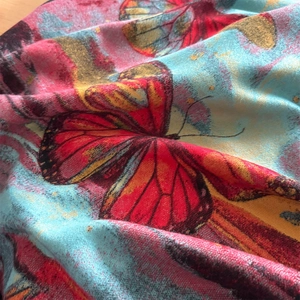 Retro faux cashmere scarf featuring red and orange butterfly prints with colorful texture