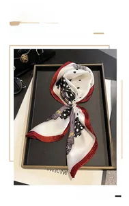 Foulard in seta con pois e pied-de-poule, fissato da una raffinata fibbia a perla lucida