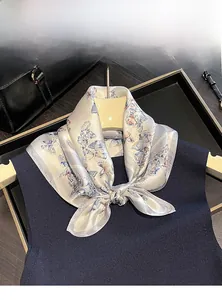 Detailed view of 100% mulberry silk scarf with blue butterfly print knotted on a navy top