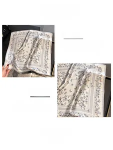 Close-up of butterfly print and overlock stitching detail on a silk neck scarf