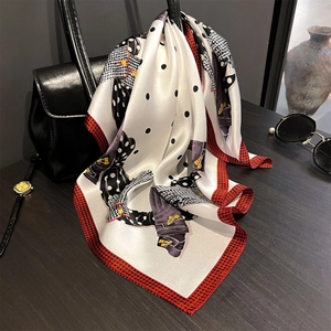 Foulard quadrato in seta con pois neri e bordo pied de poule rosso su borsa in pelle