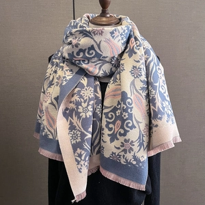 Detailed close-up of floral jacquard patterns and soft fringe on warm winter scarf