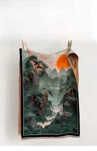 Detail of landscape art scarf featuring pine trees, sun print, and delicate tassel trim