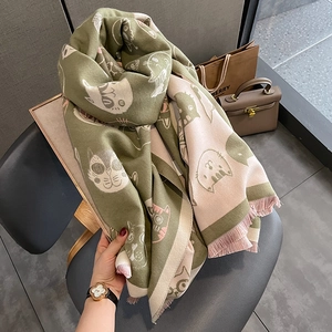 Détail d'une écharpe vert olive effet cachemire avec motifs chats et pompons roses fins