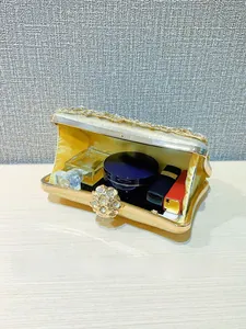 Detail of luxury gold evening bag with floral embroidery and sparkling crystal clasp