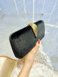 Detail of elegant black velvet evening clutch with a golden leaf metal ornament
