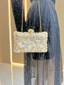 Macro shot of silver and gold evening bag with intricate rhinestone floral patterns