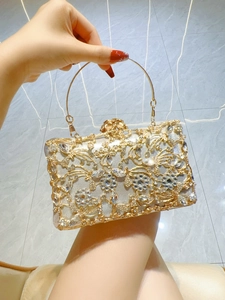 Detail of evening clutch bag featuring gold and silver hollow floral metal with rhinestones
