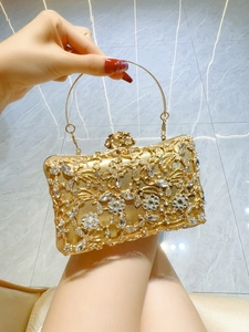 Detail of luxury gold evening clutch bag with sparkling rhinestones and floral latch
