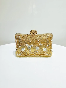Detail of luxury gold evening clutch with rhinestones and floral metal clasp