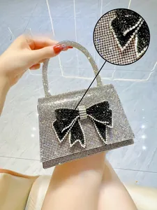 Close-up of sparkling 5A silver rhinestones and black crystal bow on a square evening bag