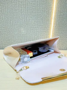 Interior view showing the large capacity of the satin evening clutch with a gold chain strap