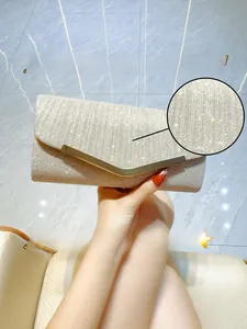 Detail of champagne gold pleated evening clutch with sequins and V-shaped metal trim