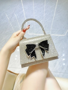 Detail of silver rhinestone evening bag featuring a large black crystal bow decoration