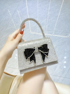 Macro shot of silver rhinestone handbag with a large black crystal bow detail