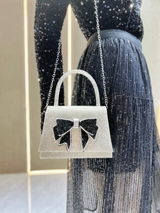 Detailed view of silver rhinestones and a black crystal bow on this elegant evening clutch