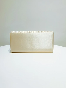 Detail of champagne satin evening clutch bag with pleated texture and rectangular shell