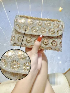 Detail van fonkelende 5A-strass-steentjes met bloemmotieven op een gouden avondtasje