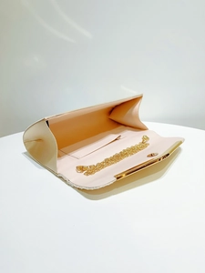 Detail view of champagne satin evening clutch with gold chain and soft pink lining