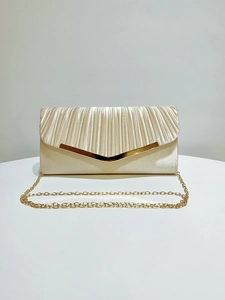 Detail of champagne satin evening clutch featuring pleated texture and gold V-shaped metal trim