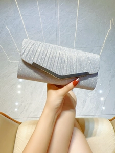 Detail of silver pleated evening clutch with sparkling glitter and V-shaped metal trim
