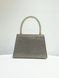 Detailed macro shot of silver rhinestones and craftsmanship on the trapezoid evening bag