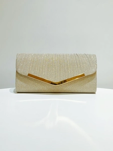 Close-up of sparkling gold pleated evening clutch with elegant V-shaped metal trim