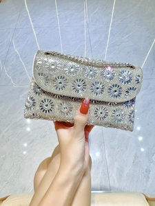 Gedetailleerde close-up van een zilveren strass avondtas met luxe kristallen bloem