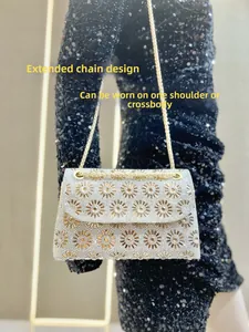 Detail van zonnebloempatroon met strass op zilveren avondtas met lange gouden ketting