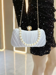 Detailed view of silver pleated satin evening bag with pearl clasp and chain strap