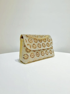 Detail van zonnebloem kristalpatronen op een luxe gouden strass avondtasje