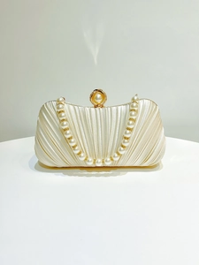 Detail of pleated satin ivory clutch featuring large pearl clasp and bead strap
